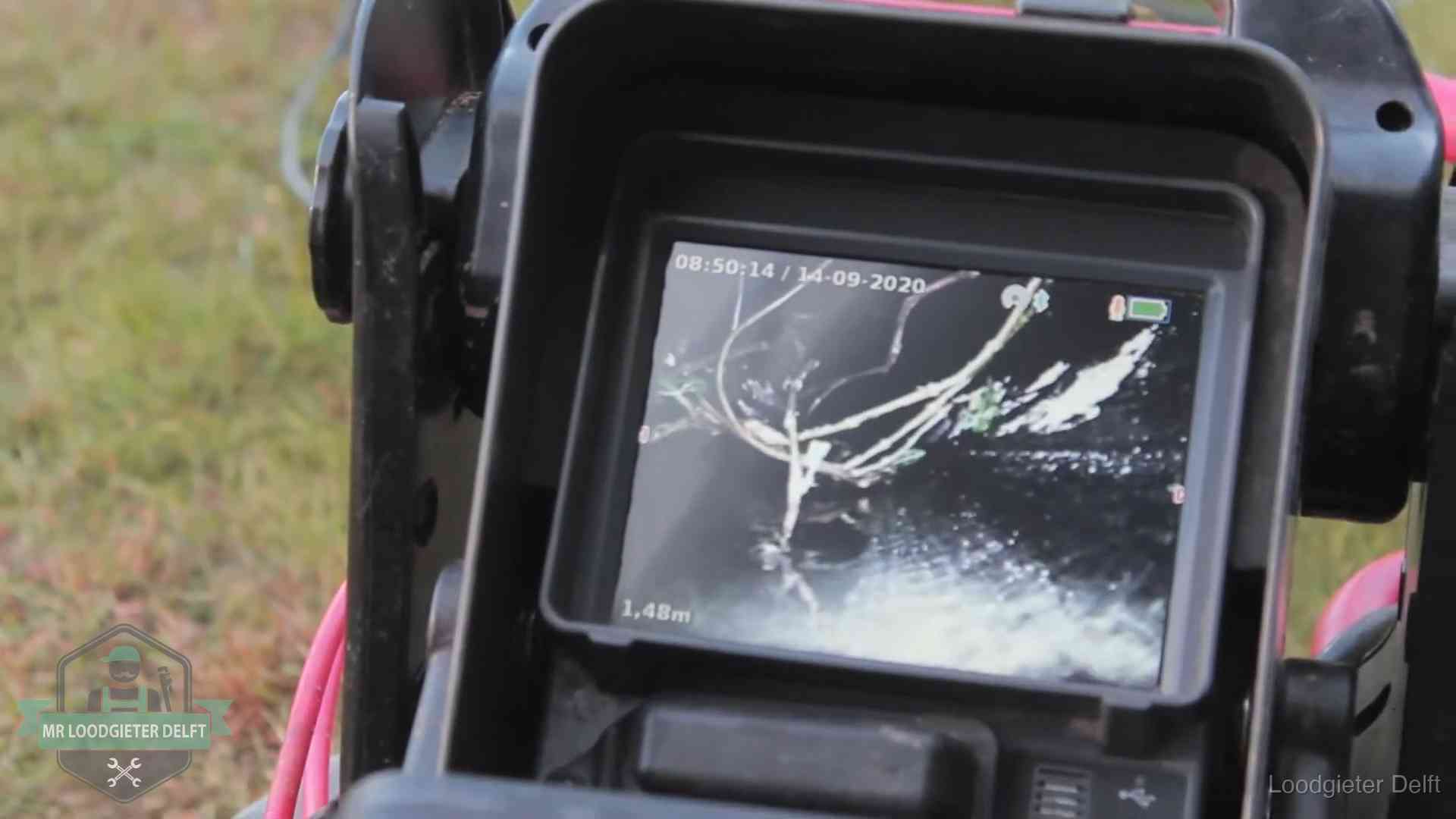 Monitor van een rioolcamera toont wortelingroei in de rioolbuis bij een woning in Delft