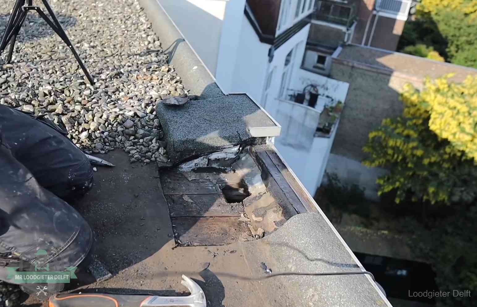 Opengelegde dakrand met verrot dakbeschot door een langdurige daklekkage in Delft