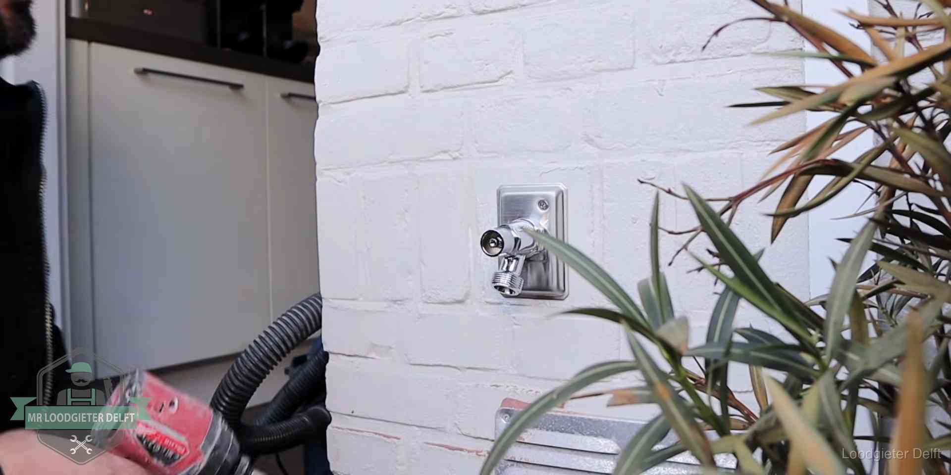 Chromen kraan op een muurplaat bij een woning in Delft, dichtdraaien is stap een van de lektest