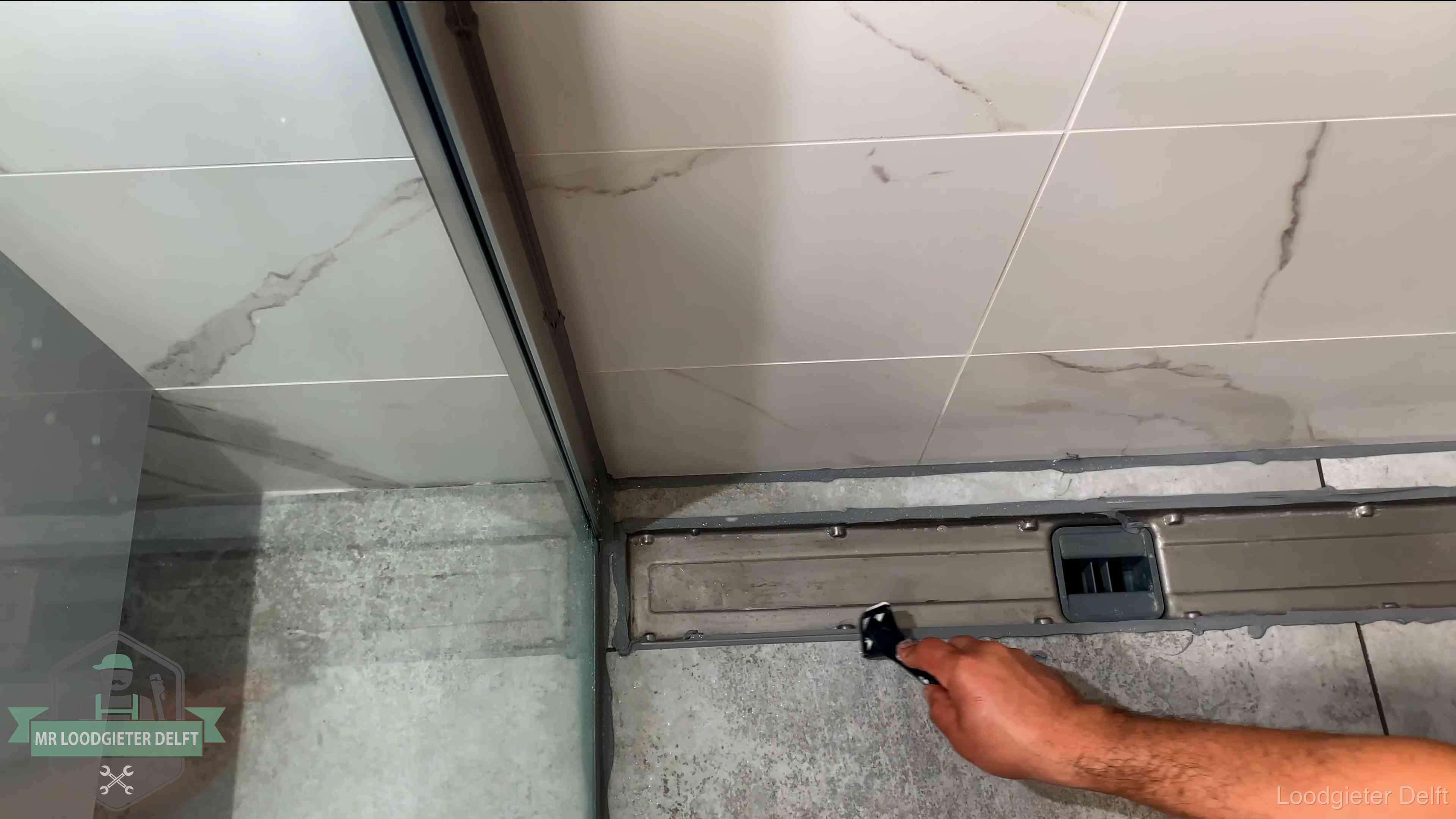 Lekkage in de badkamer verhelpen in Delft Verse kitrand langs de douchegoot in een betegelde badkamer in Delft