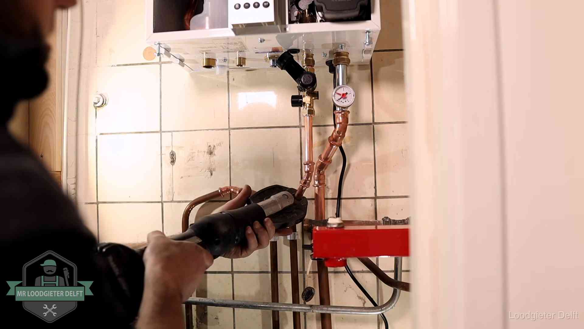 Cv-ketel onderhoud in Delft Monteur werkt aan de leidingen onder een cv-ketel in Delft