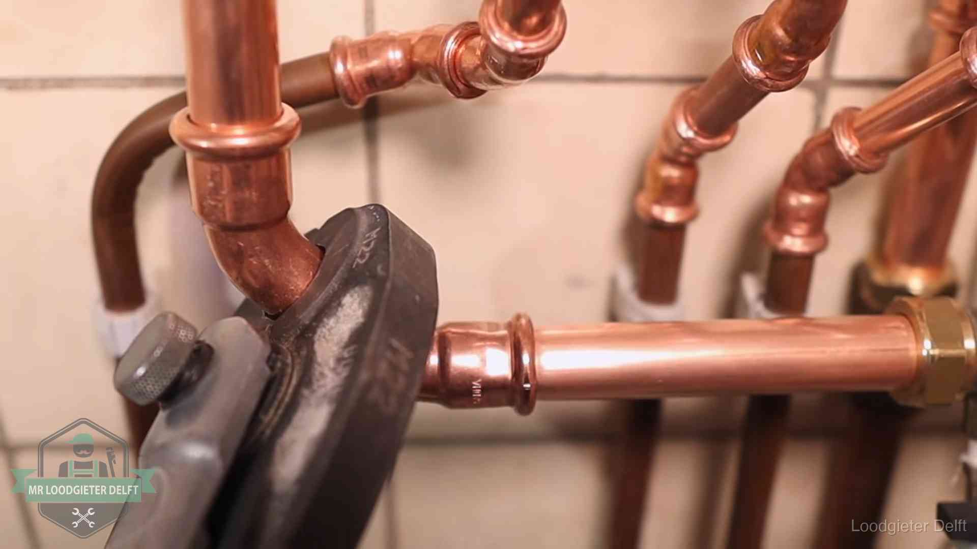 Werkwijze van ons loodgietersbedrijf in Delft Persmachine perst een koperen fitting op nieuw leidingwerk in Delft
