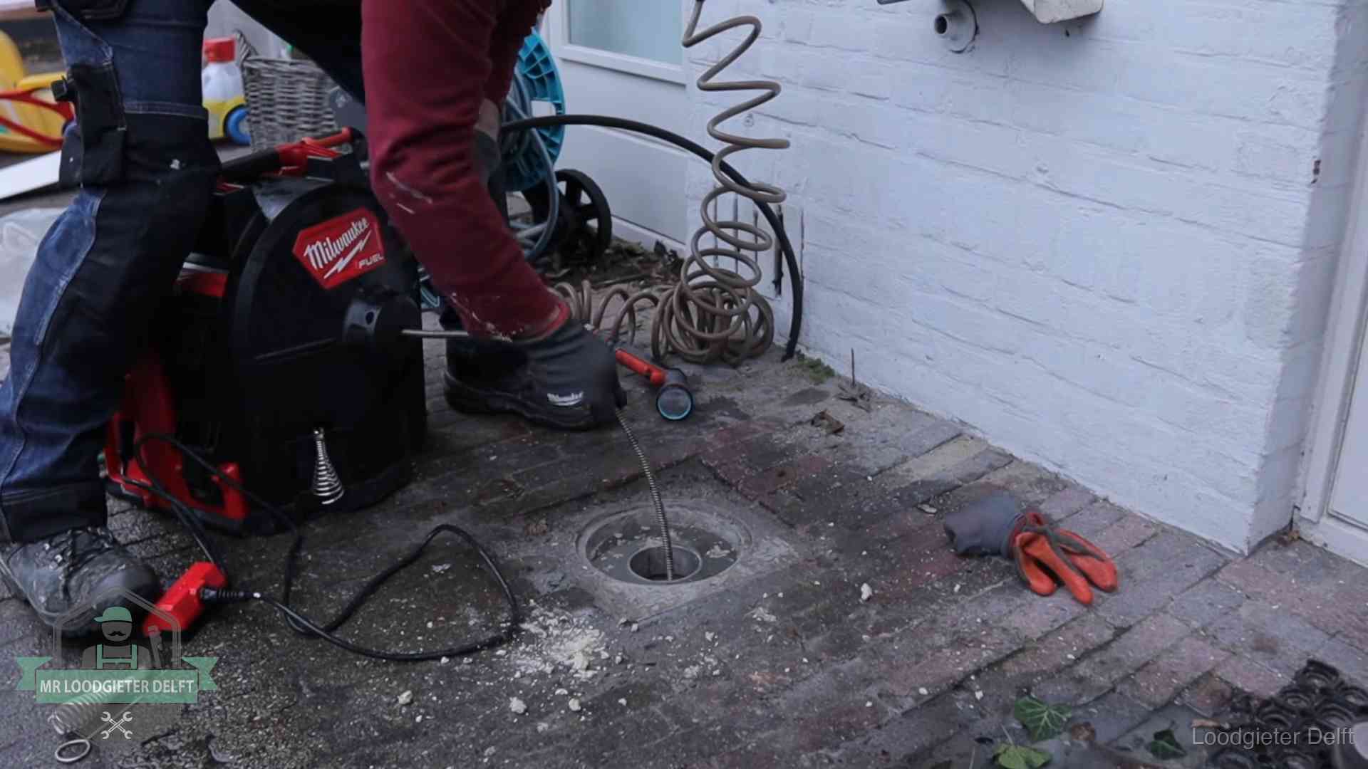 Spiraalmachine bij een ontstoppingsputje in de bestrating in Delft