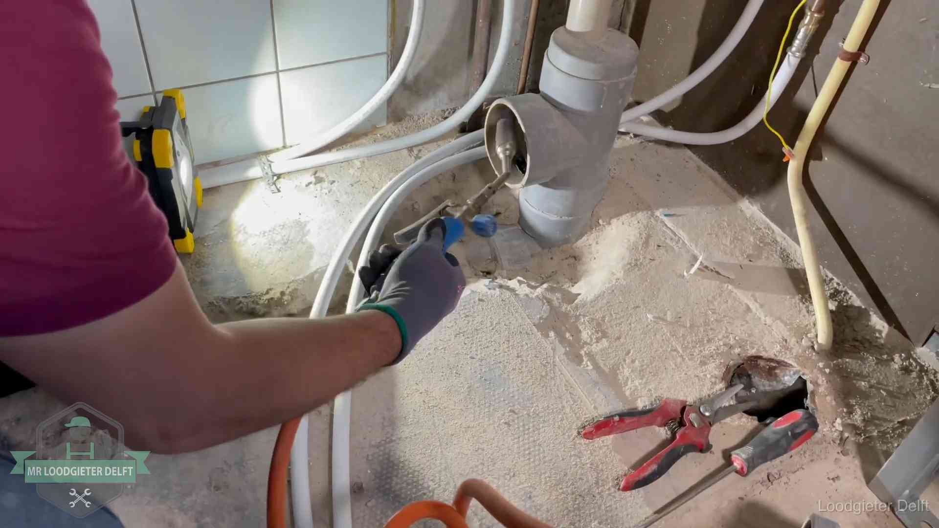 Standleiding en gedeelde leidingen in Delft Loodgieter werkt aan leidingen bij een pvc-standleiding in een appartement in Delft