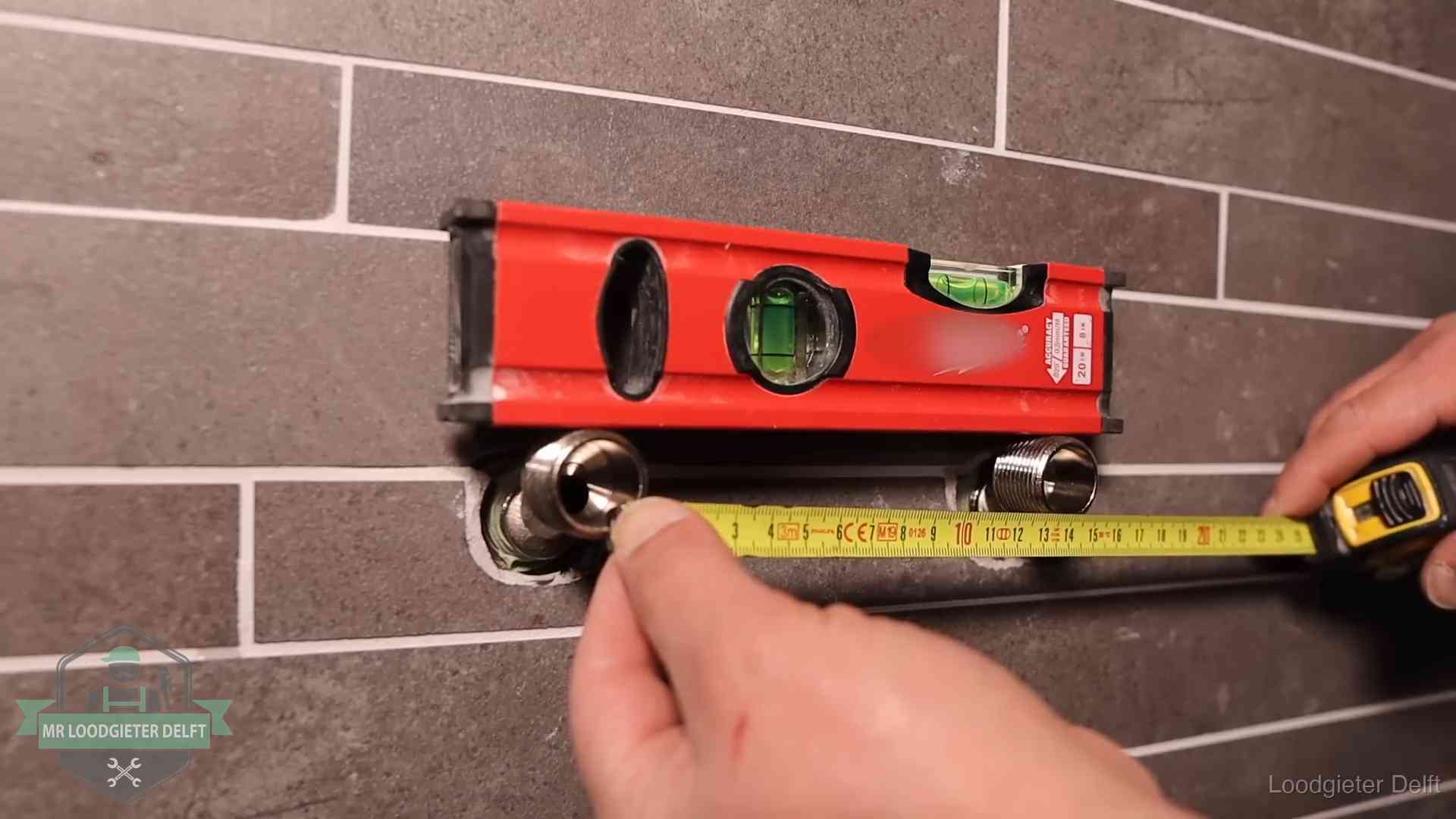 Kwaliteit en je vangnet als klant in Delft Waterpas en duimstok bij kraan-aansluitpunten in een badkamer in Delft