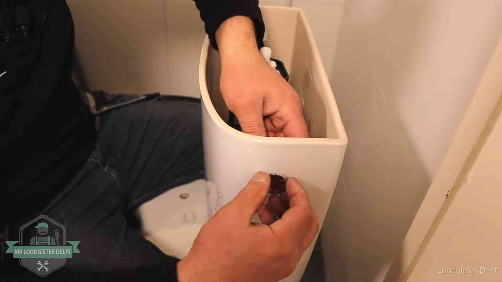 Je wc verstoppingsvrij houden in Delft Drukknop van een duoblok-stortbak wordt gemonteerd bij een toilet in Delft