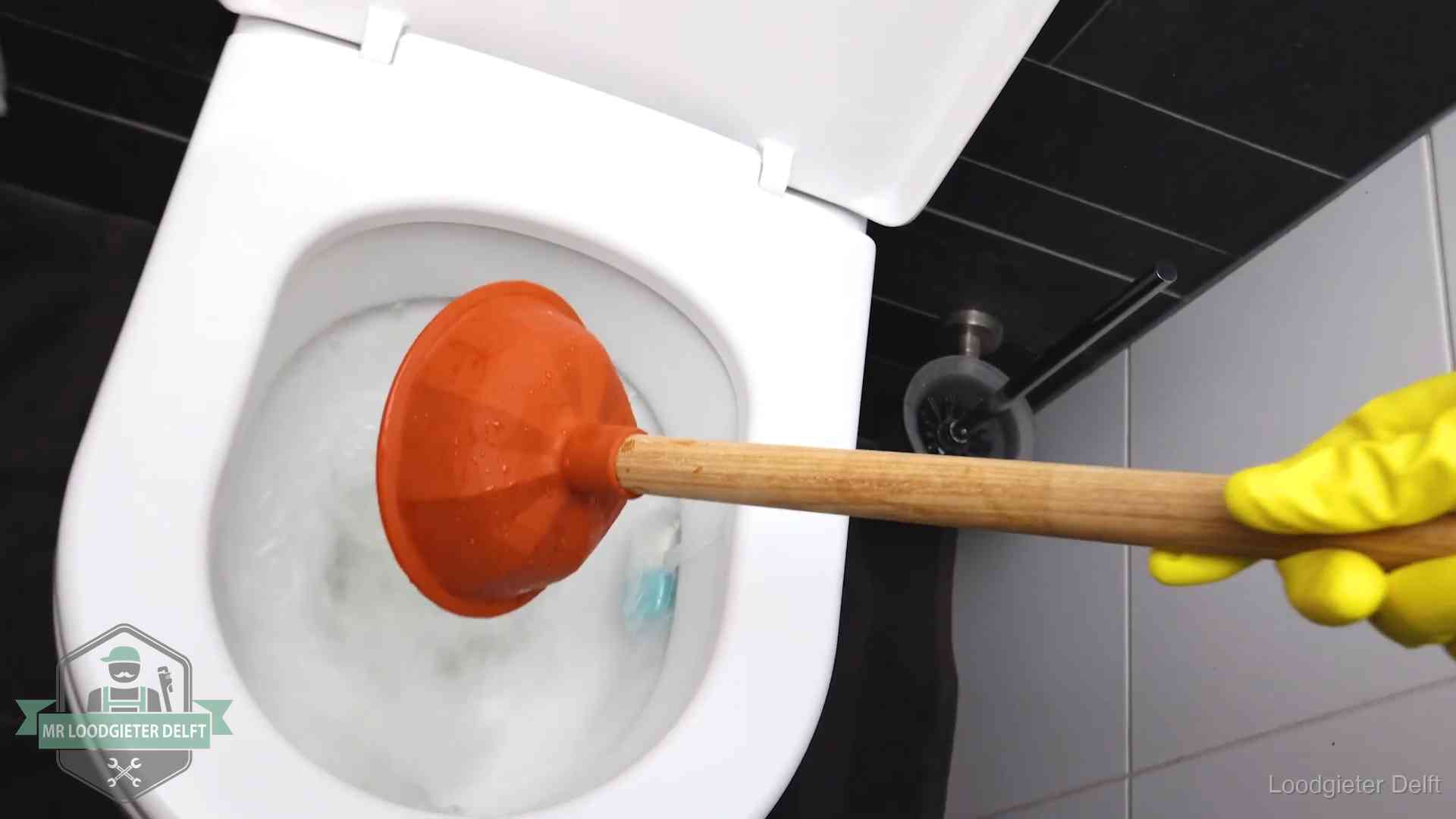 Wc ontstoppen met de plopper in Delft Plopper wordt in de wc-pot gedrukt bij het ontstoppen van een toilet in Delft
