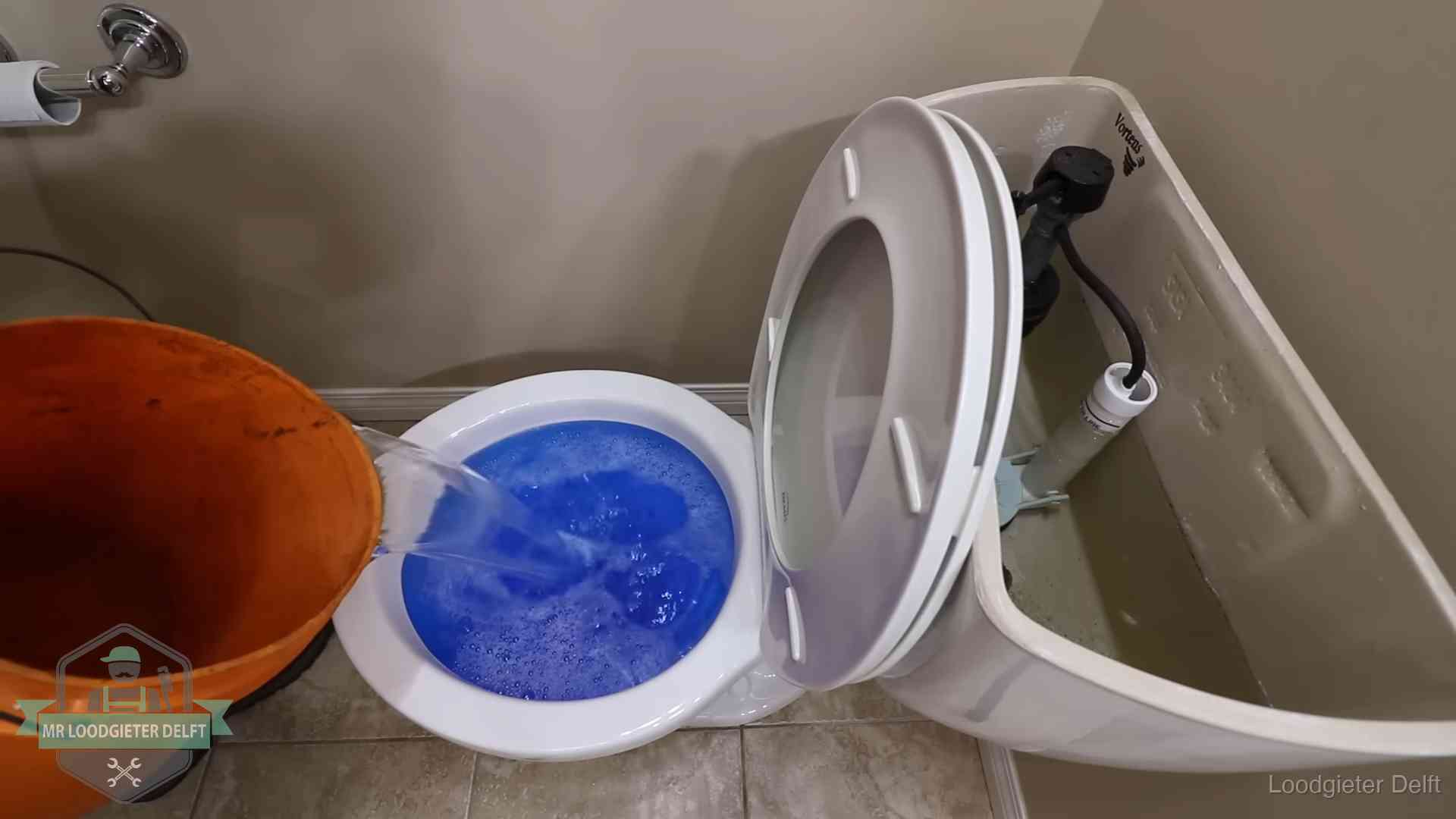 Water komt omhoog in de wc in Delft Water bij de wc-pot wordt met een emmer weggewerkt om schade te beperken in Delft